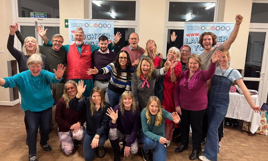 A group of participants taking part in a laughter yoga class