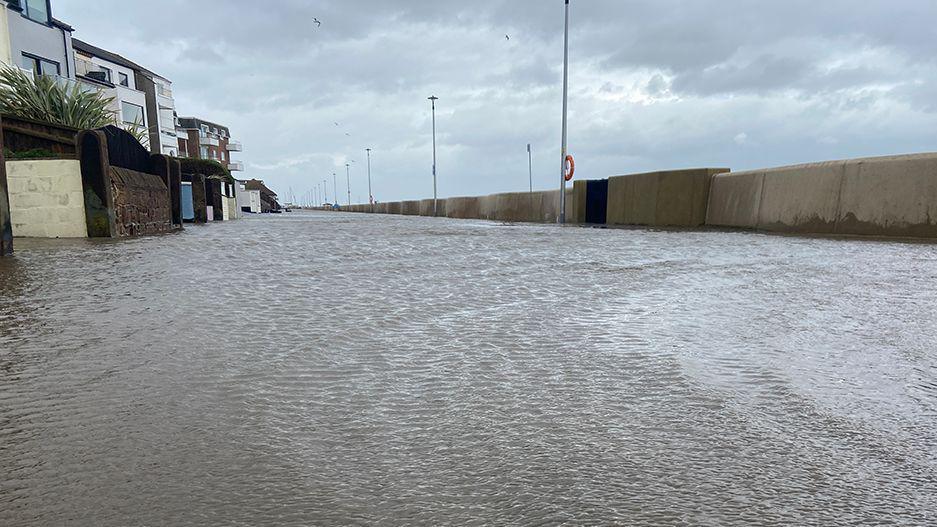 A flooded South Parade in West Kirby showing water flooding the promenade