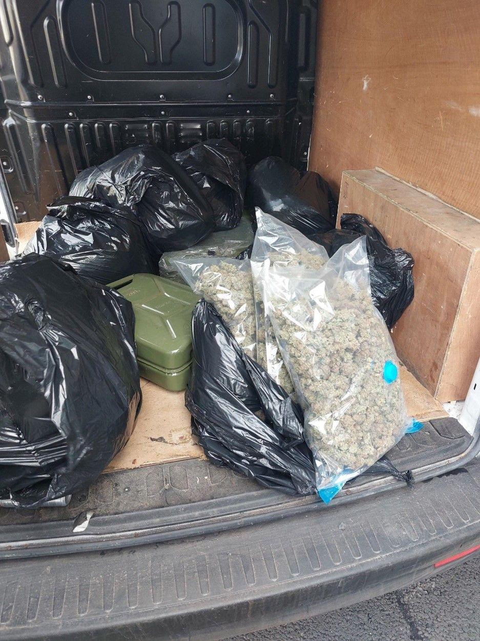 A van filled with black bags and two clear bags of cannabis