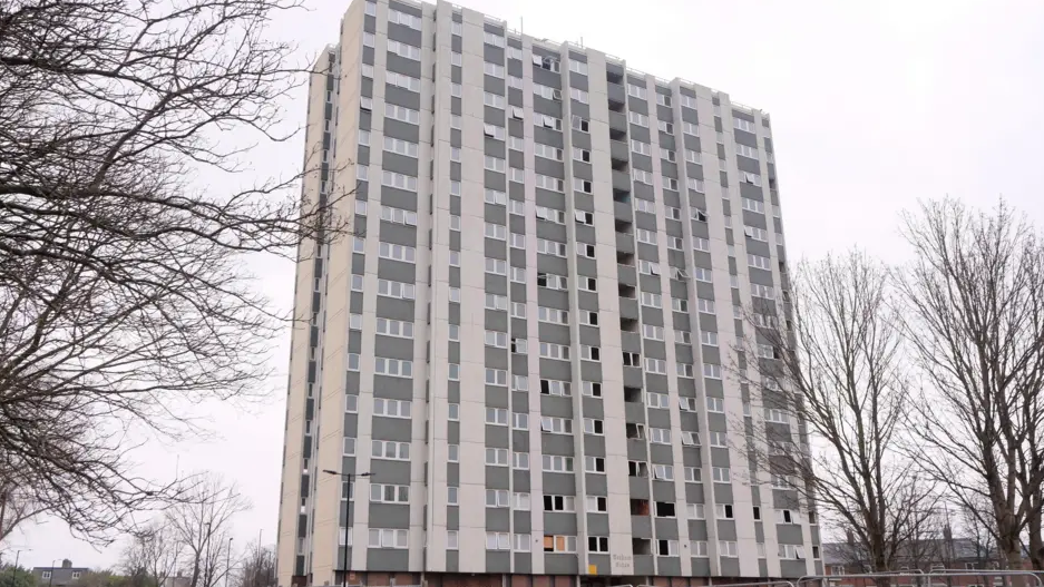 Massive wide tower block set against a grey sky.