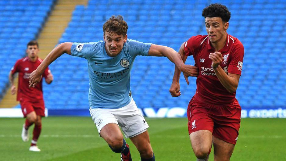 Colin Rosler playing for Manchester City against Liverpool's Curtis Jones in a PL2 game in 2018