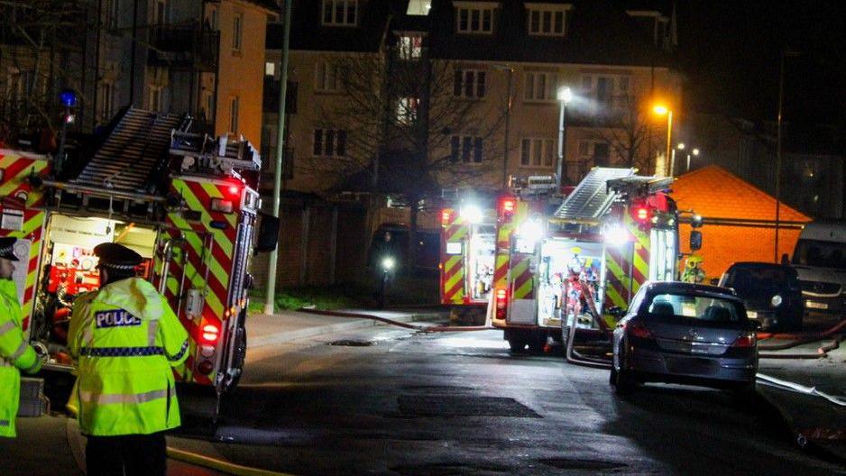 Night time view of a street lined with fire engines