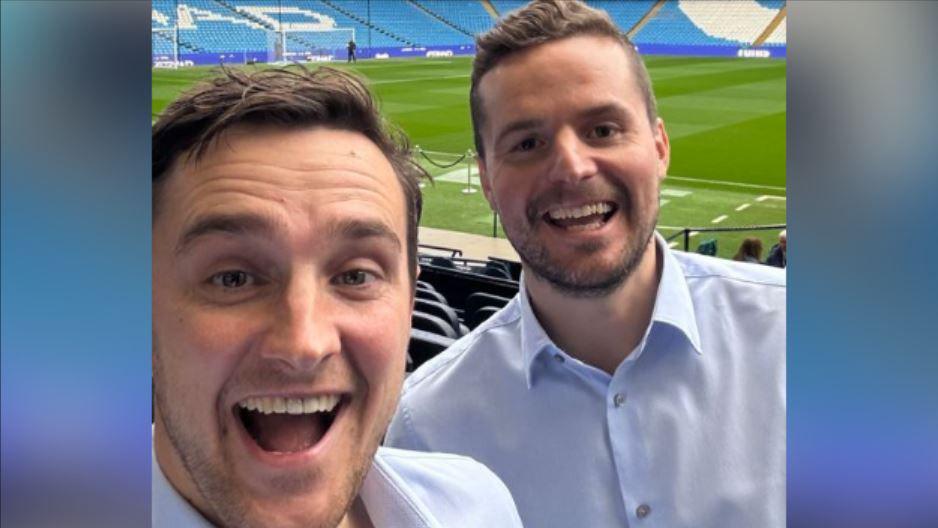 Image of Ross and Ben in the stands at Manchester City's Etihad Stadium - they were wearing pale blue shirts and are smiling at the camera