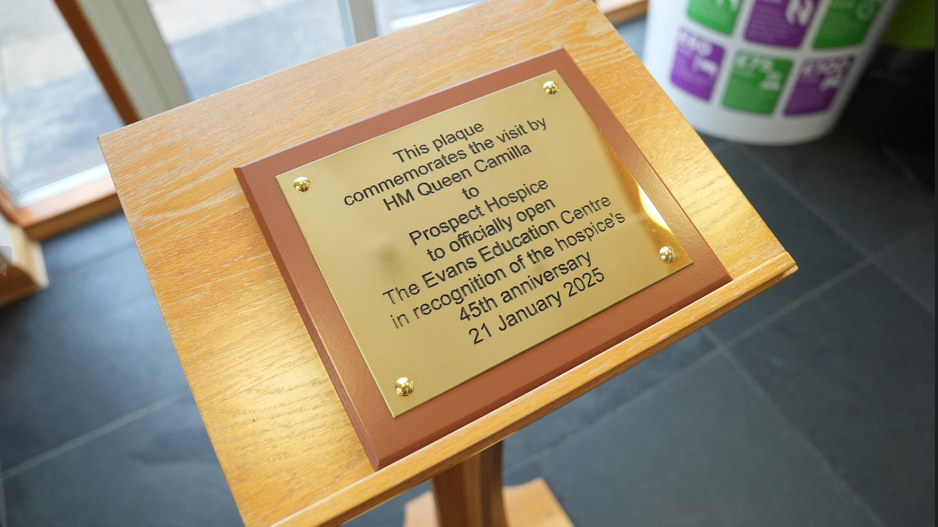 A plaque resting on a podium with the word: "this plaque commemorates the visit by HM Queen Camilla to Prospect Hospice to officially open The Evans Education Centre in recognition of the hospice's 45th anniversary, 21 January 2025"