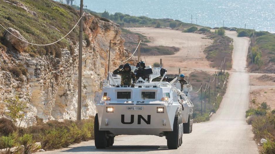 A UN peacekeeper vehicle drives along a road in Naqoura, near the Lebanese-Israeli border, southern Lebanon. In the background, the sea can be seen. 