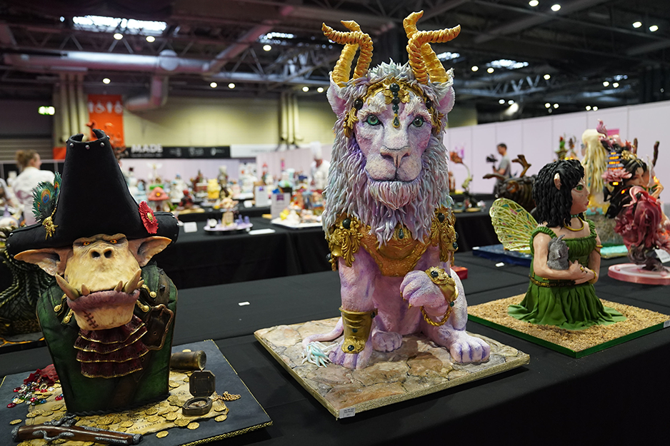 More fantastical creations made from cake. A long-toothed goblin in a green period outfit sits alongside a pink lion with horns and a winged fairy in a green dress