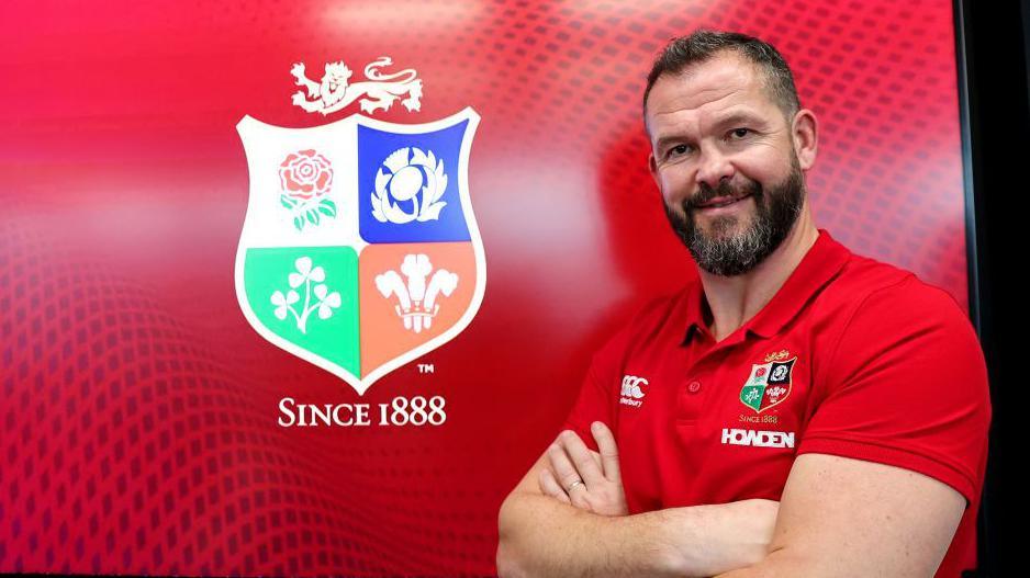 Andy Farrell standing in front of a Lions logo