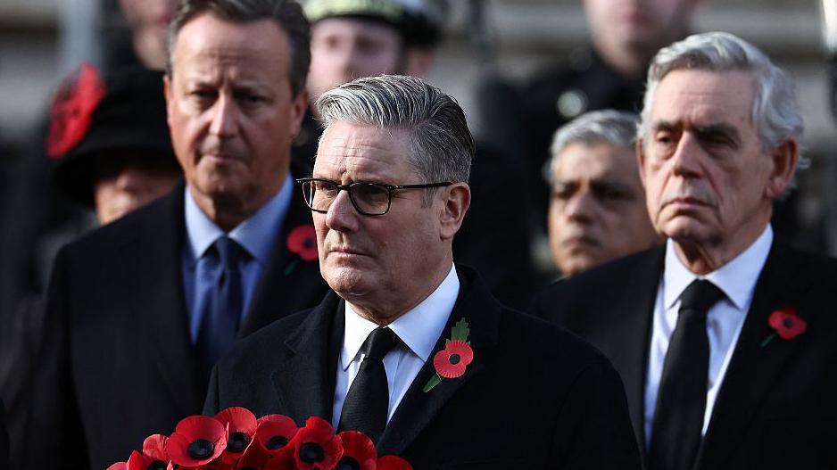 Kryeministri i Britanisë, Keir Starmer, mban kurorën e tij ndërsa ish-kryeministrat David Cameron (mbrapa majtas) dhe Gordon Brown (mbrapa djathtas).