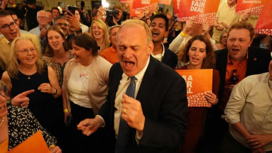 Liberal Democrat leader Sir Ed Davey with his mouth wide open and surrounded by his supporters at the London Art Bar in central London watching the results of the 2024 General Election