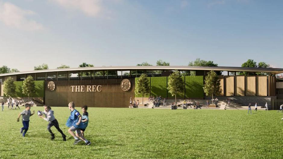 CGI image of what the stadium could look like, from the side of the green spaces surrounding the stadium. A bronze buildings boasts the name "THE REC" and there are children playing on the green.