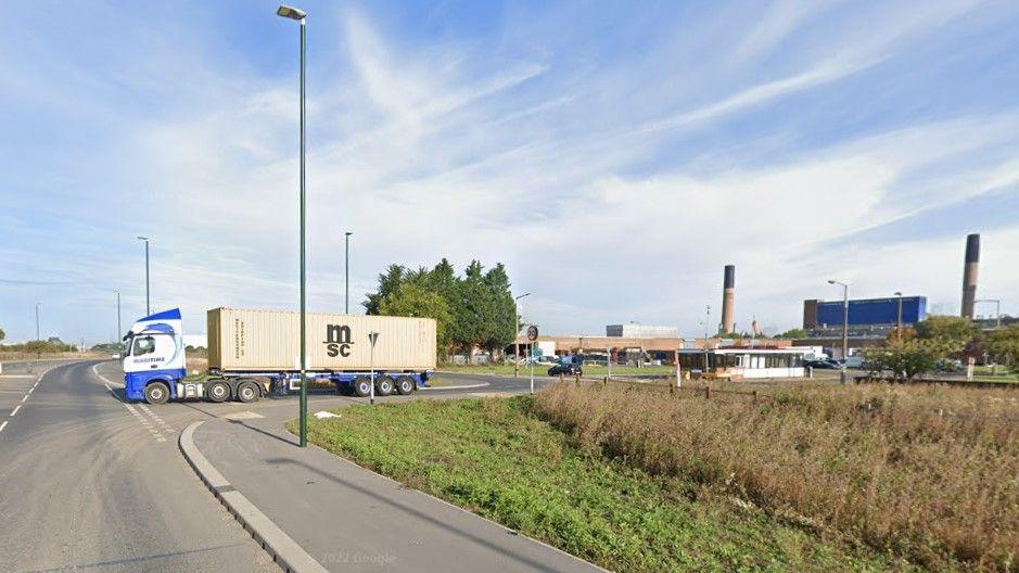 A lorry exits a road off Energy Way in Grimsby, with factories and a power station in the background