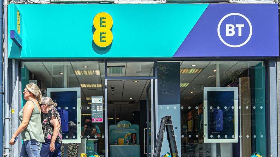 Person walking outside an EE store