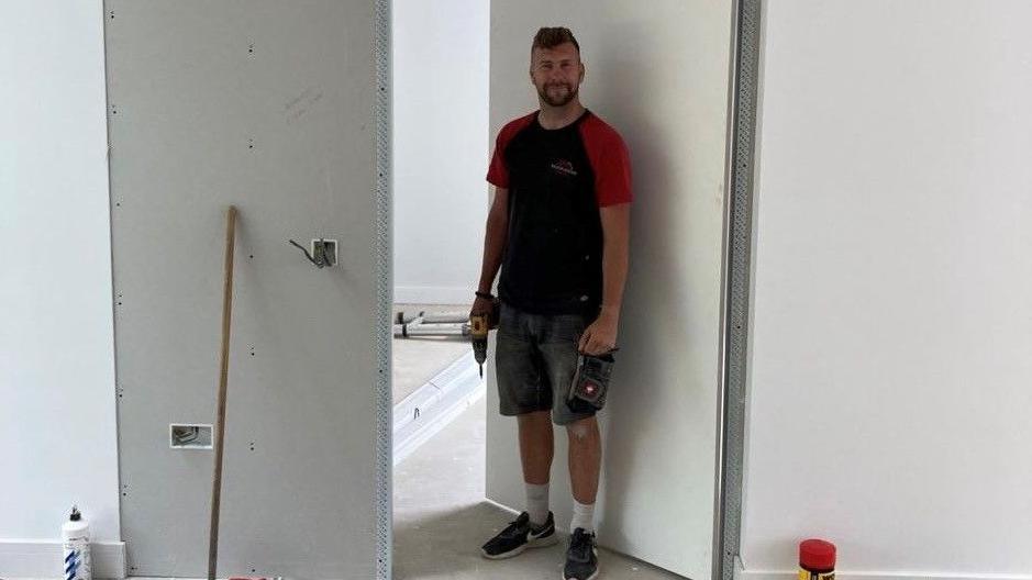 Scott Arnold stood in a blank white room with tools in hand