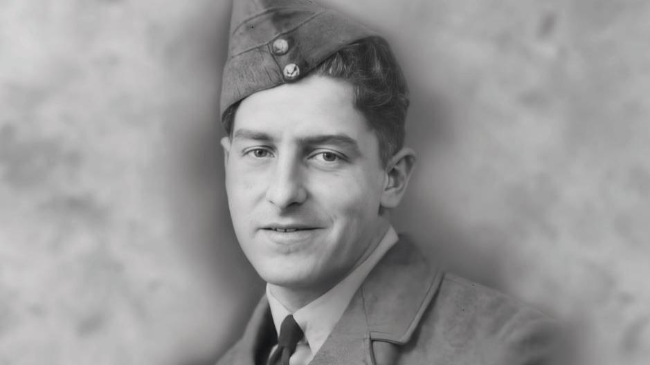 The photograph is black and white and shows a man in regimental wear.