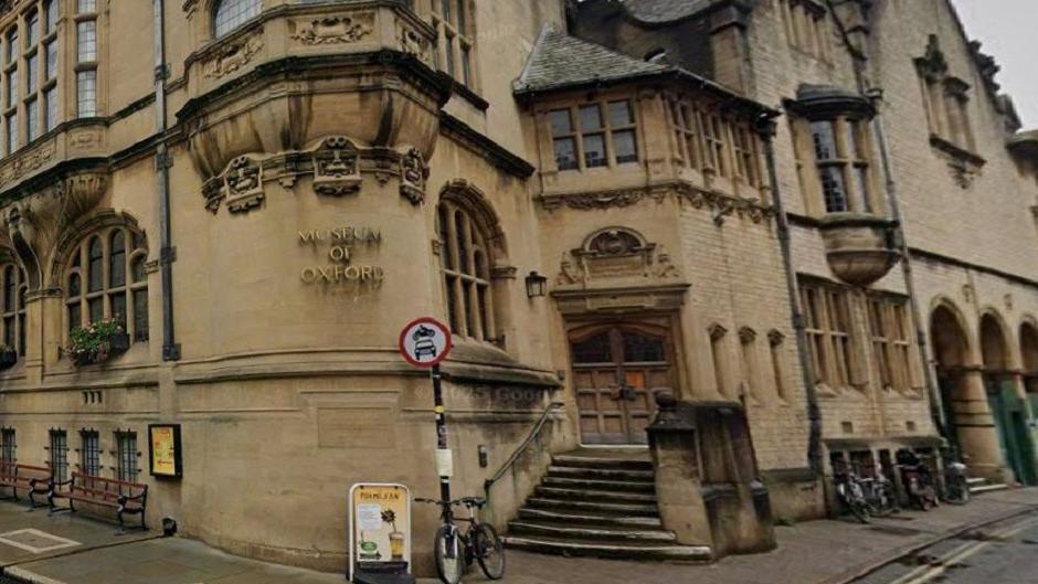 The exterior of the Museum of Oxford, with light-brown stone.