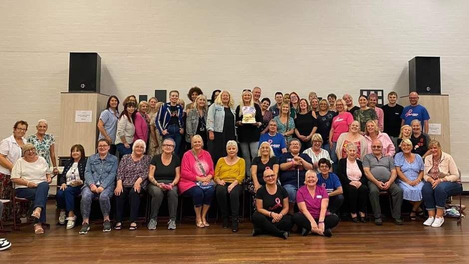 The cancer support group Pink Sisters and Misters pose for a photo commemorating their eighth birthday.