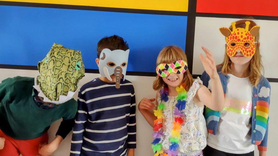 Four children from York Kids Art Open Studios line up wearing animal masks - there are two boys, Seth and HS, and two girls, Ada and Mabel.