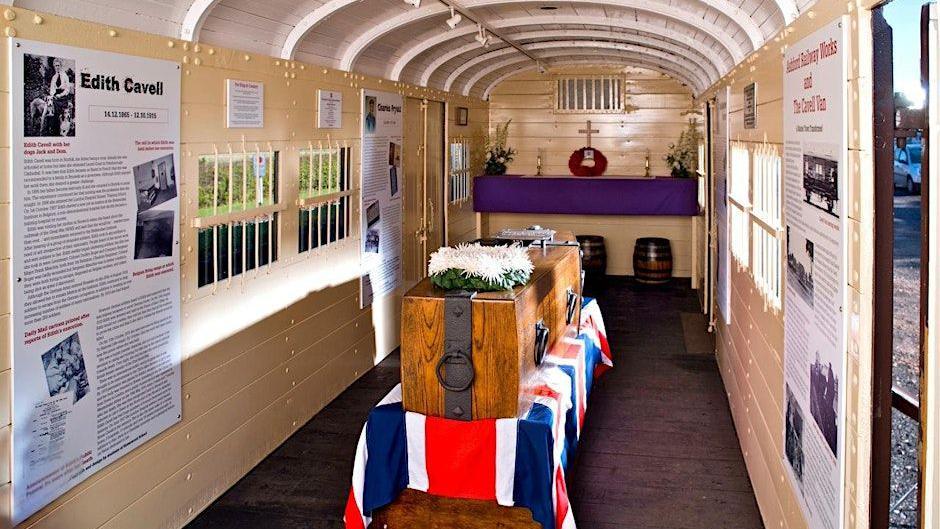 The interior of the Cavell van, featuring a coffin on a union flag, a small altar and information posters about the people it was used to repatriate.