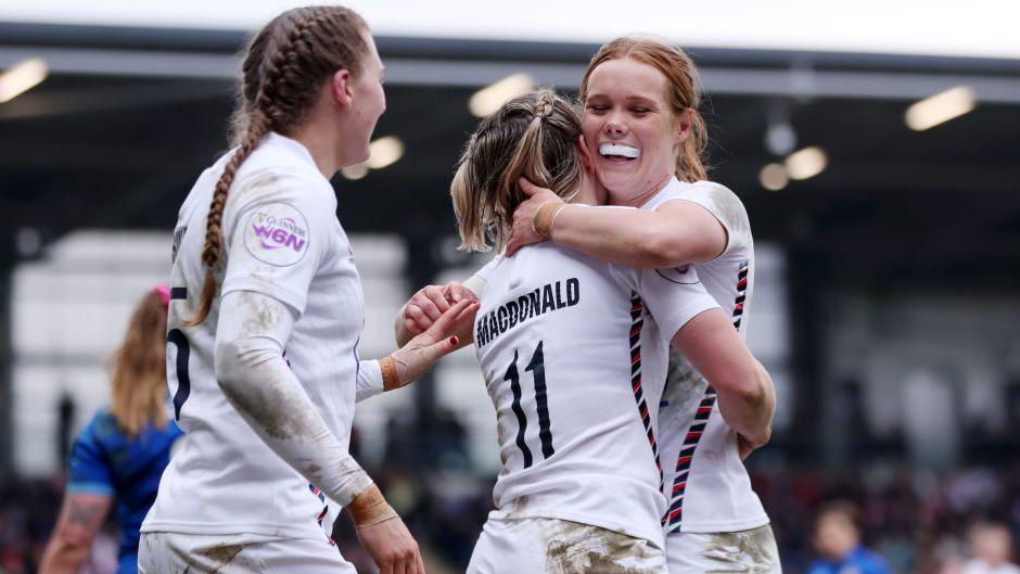 Claudia MacDonald of England celebrates scoring her team's third try with team-mate Mia Venner