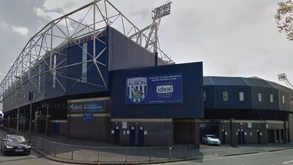 A side view of The Hawthorns ground in West Bromwich. The ground's blue decor can be seen with an entrance on the right hand side.