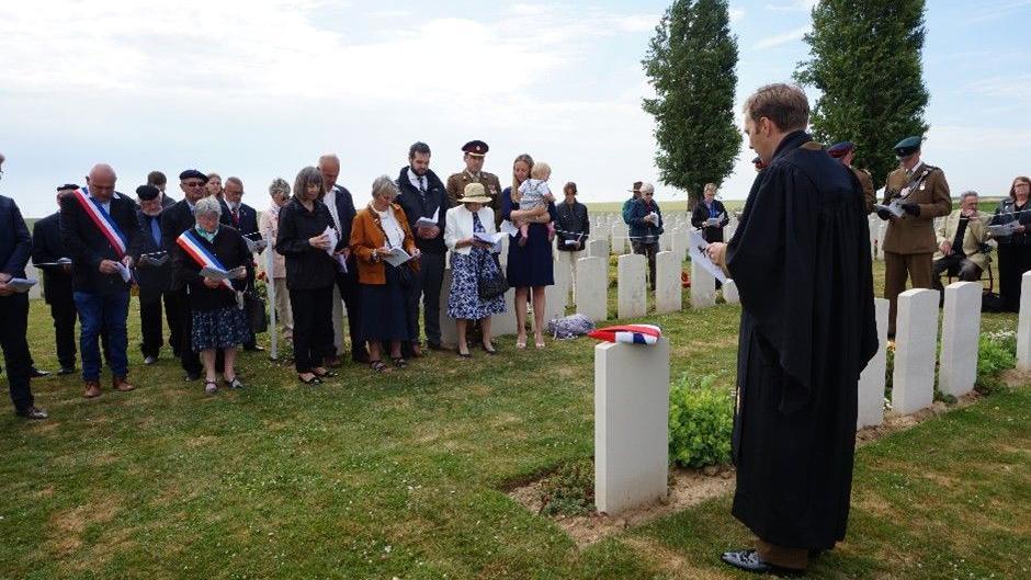 Lt Osmond Wordsworth grave re-dedication ceremony. Civilians and soldiers are in attendance. Some are wearing the French flag.