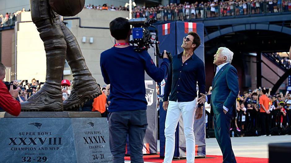 Tom Brady looks up at his statue with New England Patriots owner Robert Kraft