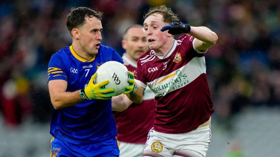 Ballymacelligott's Micheal Reidy is tackled by Darragh Mellon
