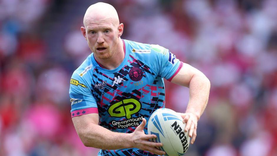 Liam Farrell of Wigan Warriors runs with the ball during the Betfred Challenge Cup semi-final match between Hull KR and Wigan Warriors at Eco-Power Stadium on May 18, 2024