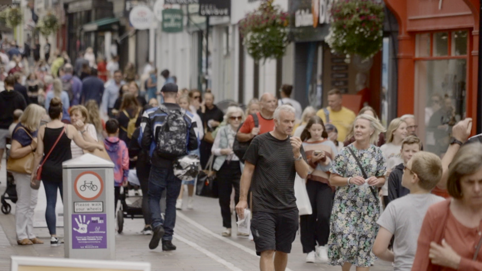 People walking down a very busy high street in St Helier.