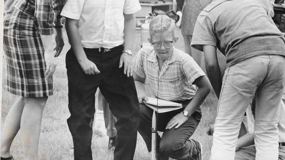 A black and white image of Paul and other pupils at Cape View Elementary in the 1960s with a model rocket.