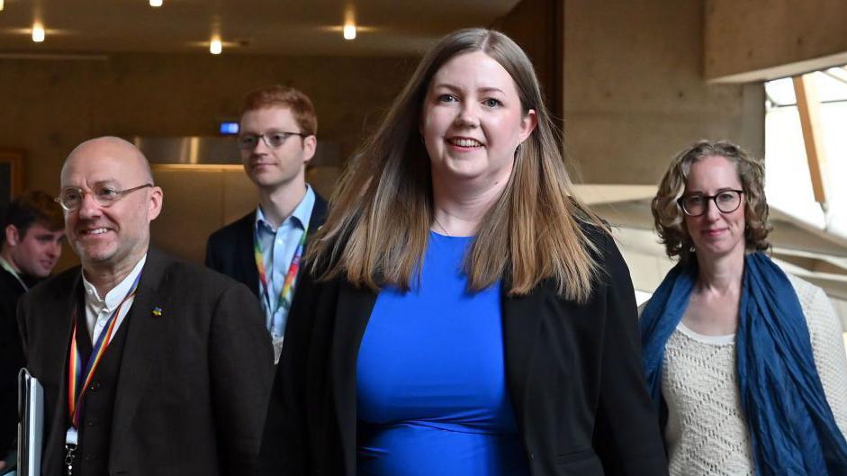 From left to right Patrick Harvie, Ross Greer, Gillian Harvey and Lorna Slater walking through a corridor at Holyrood.