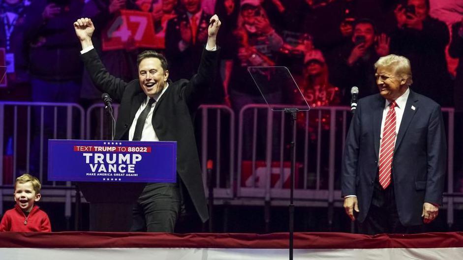 Elon Musk and Donald Trump on stage at a campaign event