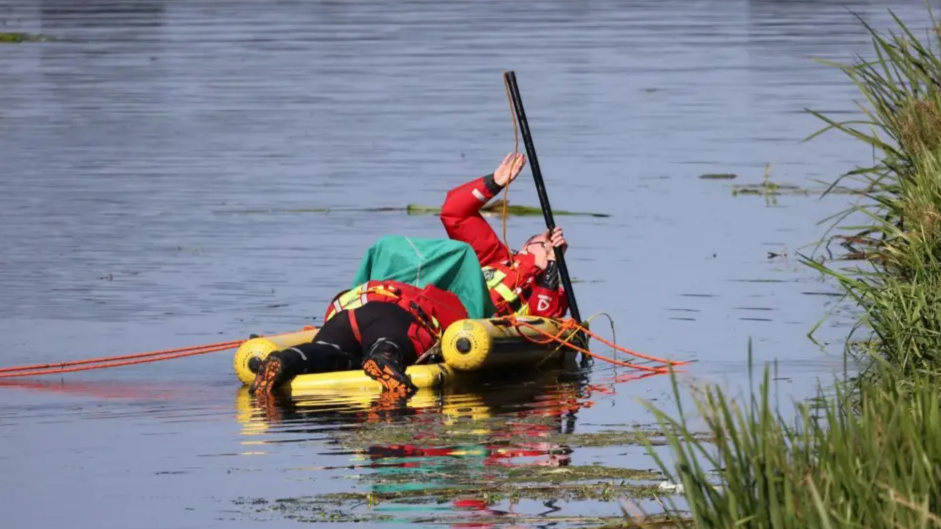 Police divers in a lifeboat dinghy searching the water