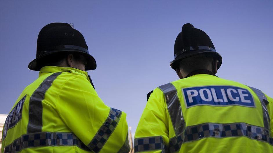 Two police officers facing away from the camera