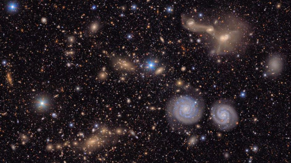 An image of the Virgo cluster taken by Vera C. Rubin Observatory. Visible are two prominent spiral galaxies (lower right), three merging galaxies (upper right), several groups of distant galaxies, many stars in the Milky Way galaxy and more.