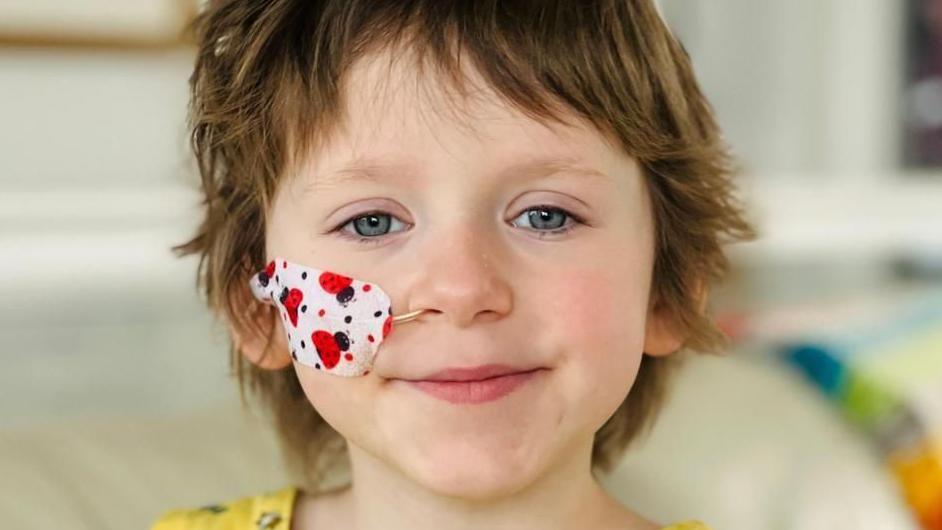 Annabel Ashmore. The five-year-old has short brown hair and blue eyes. She has a tube running to her nose which is covered with a plaster decorated with ladybirds.