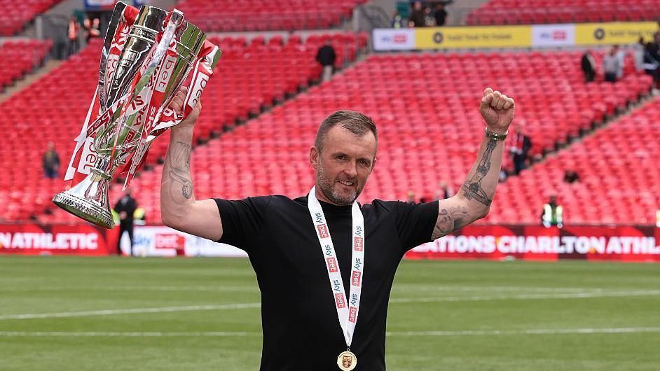 Nathan Jones holds aloft the League Two play-off trophy