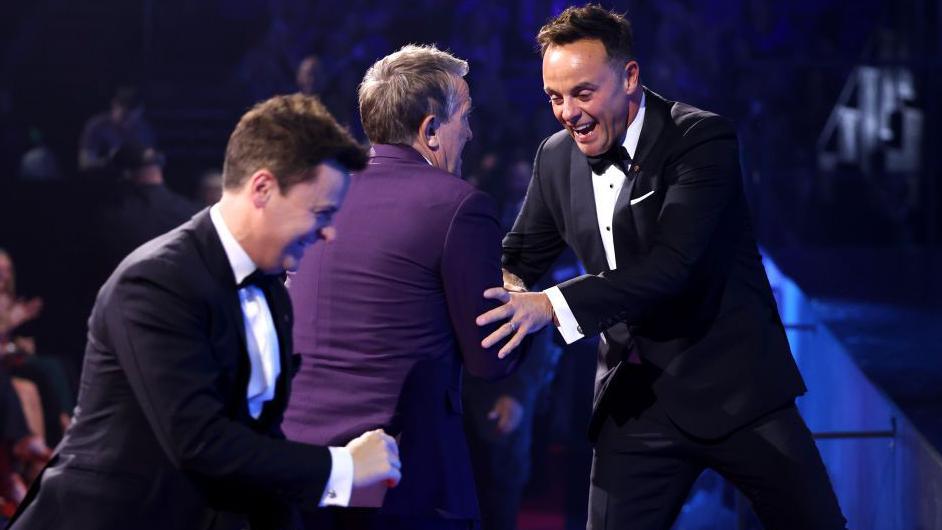 TV presenter Bradley Walsh does a fake tackle of Ant and Dec as they head on stage to collect an award