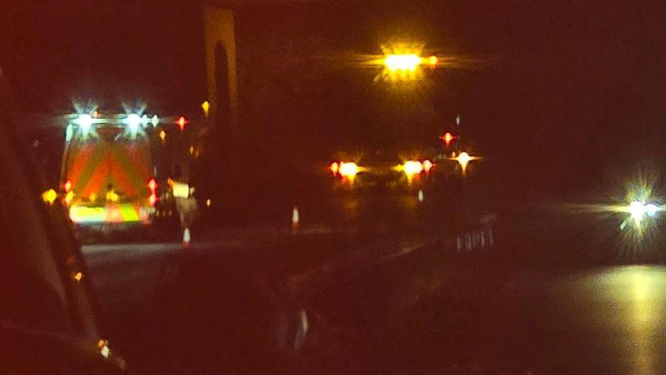 Emergency services with lights on in the dark on the road photographed from a car.