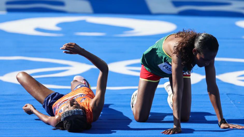 Tigst Assefa and Sifan Hassan lie on the ground after battling for Olympic gold at Paris 2024
