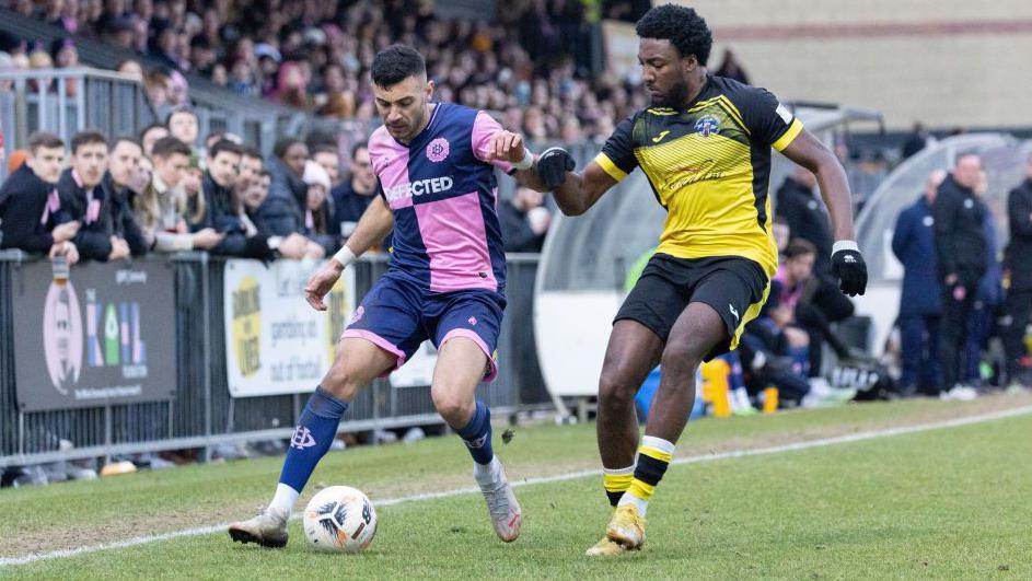 George Porter of Dulwich Hamlet is challenged by Devonte Aransibia of Tonbridge during the National League South match between Dulwich Hamlet FC v Tonbridge at Champion Hill on February 11, 2023