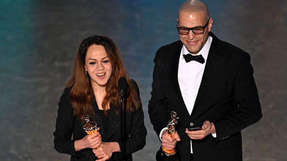 TOPSHOT - Iranian animator and film director Shirin Sohani (L) and Iranian animator Hossein Molayemi accept the award for Best Animated Short Film