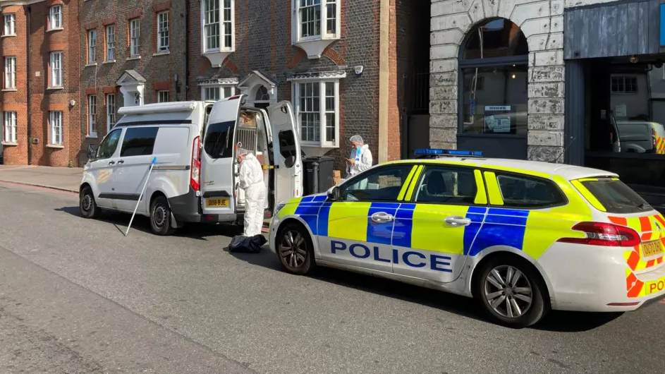A picture of forensic officers taken from western side of stabbing scene.