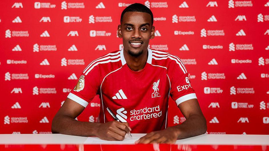 Alexander Isak signing a contract for Liverpool