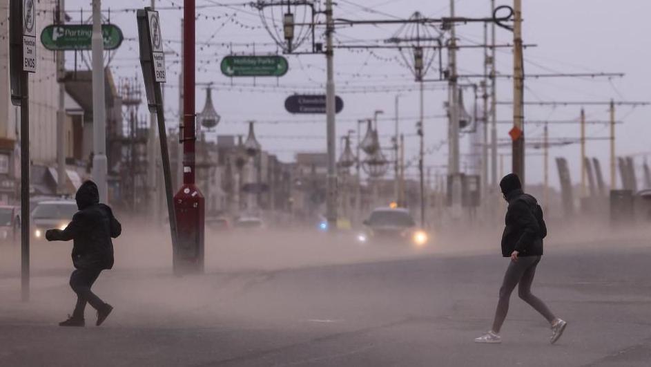 People walking through a storm in Blackpool