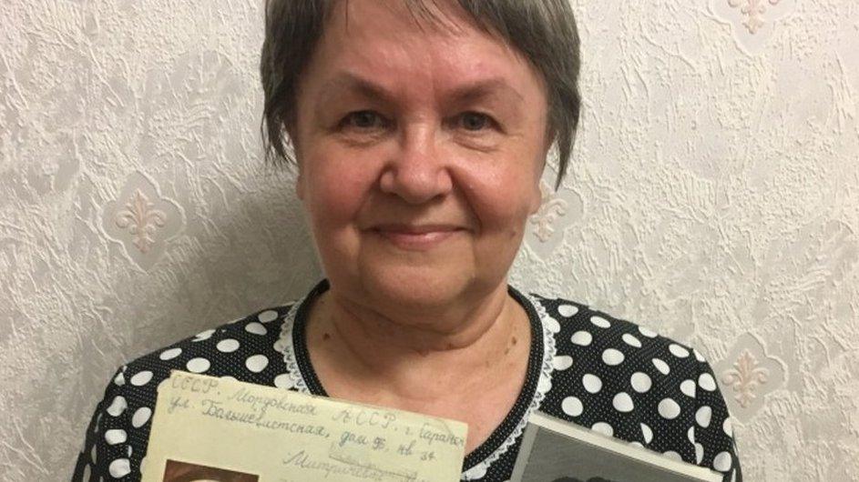 Lyudmila Mitricheva, holding up a letter written in Russian and a photo of her Chinese pen pal