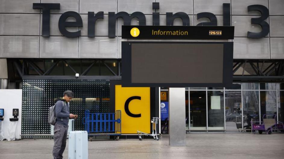 A person standing at a terminal at Heathrow