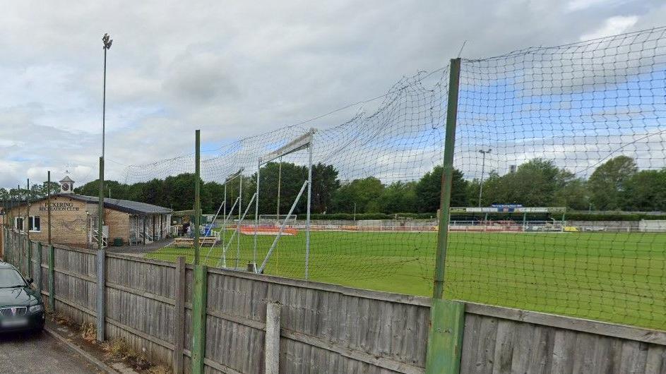 Exterior shot of a recreation ground with a pavilion and football goal posts