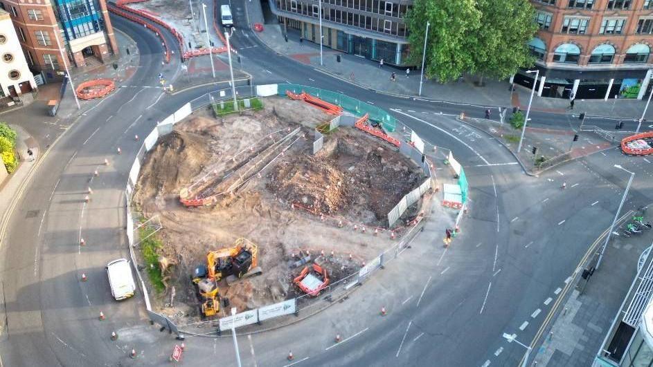 Drone shot of the old roundabout, taken from an angle above, showing work already started with machines and piles of rubble in the centre