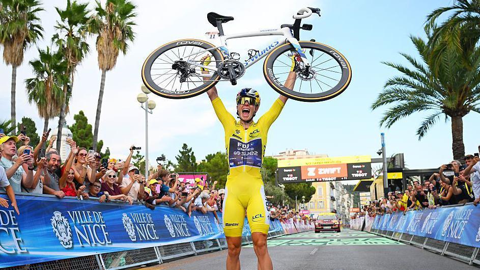 Demi Vollering lifts her bike to celebrate after winning the final stage of the 2026 Tour de France Femmes to secure the general classification title